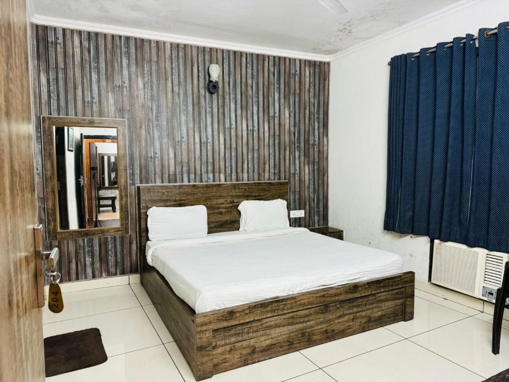 sypialnia z łóżkiem i niebieską zasłoną w obiekcie Hotel Pearl inn w mieście Rudrapur