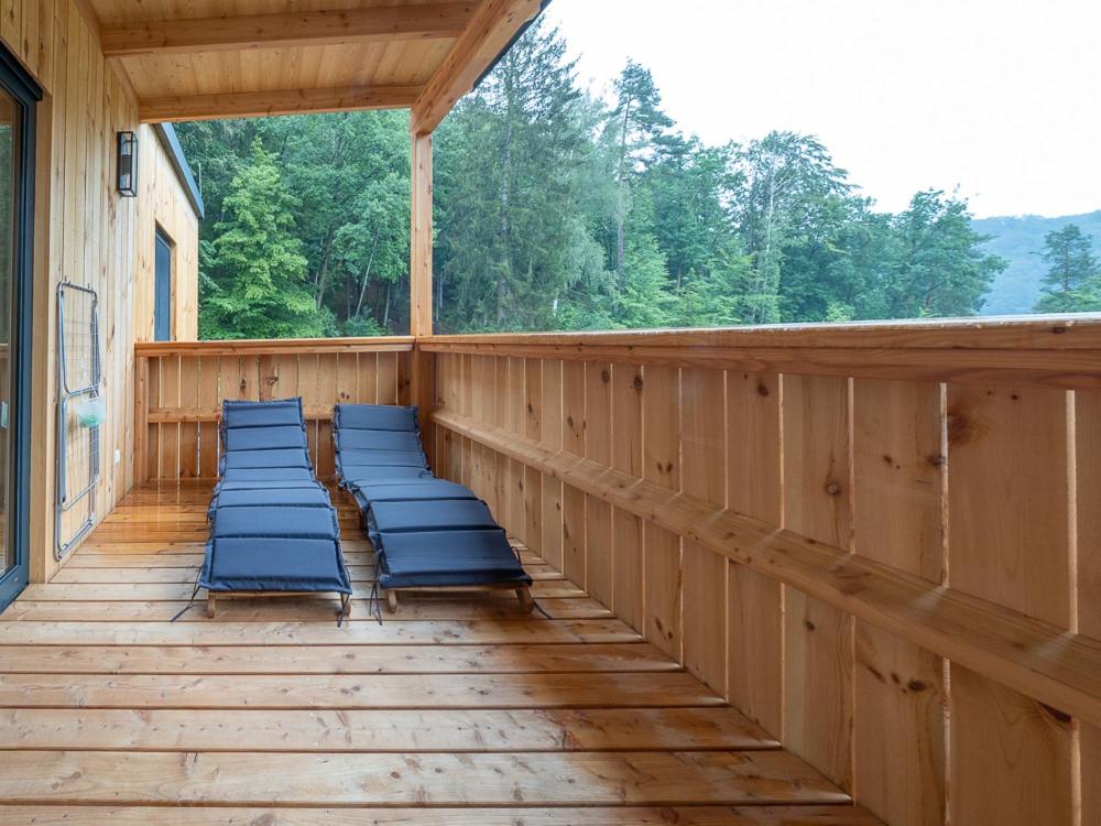 a porch with blue chairs on a wooden deck at Seehäuser Dobra 