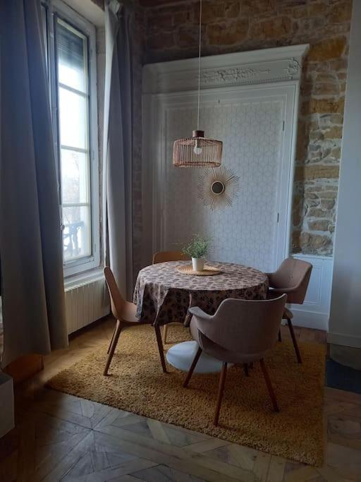a dining room with a table and chairs and a window at Le petit Opéra in Lyon