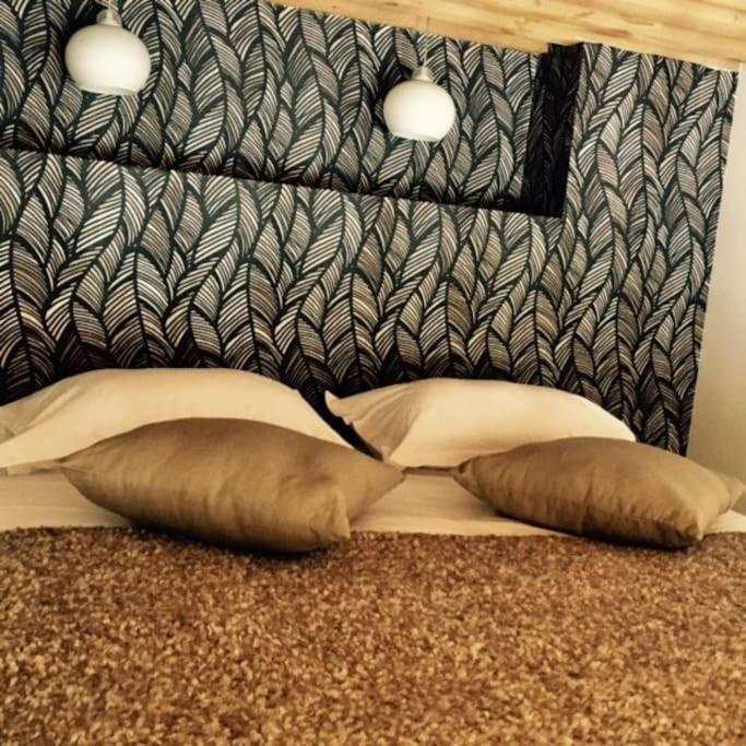 a bed with two pillows and a black and white headboard at Le petit Opéra in Lyon
