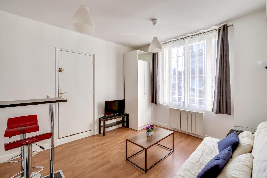 a living room with a couch and a table at Studio 2 pers - Wifi limite Vincennes & métro (E3) in Montreuil