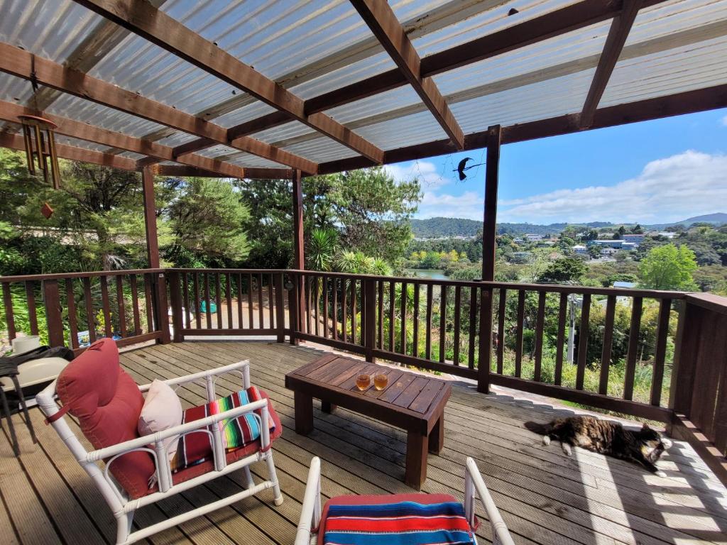 a patio with a table and a cat laying on a deck at City Retreat in Whangarei