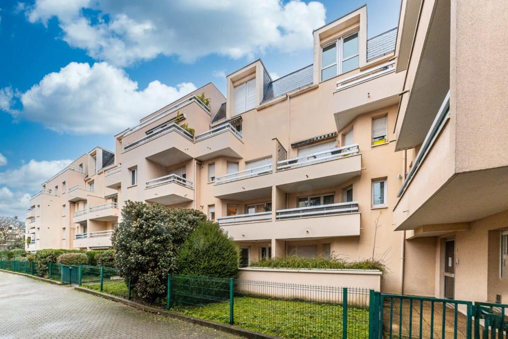 an apartment building with solar panels on it at Le CosyNaï - 20min to Paris in Sannois