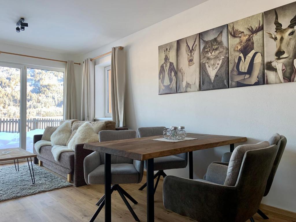 a living room with a table and chairs at Almlodge Flachau in Flachau