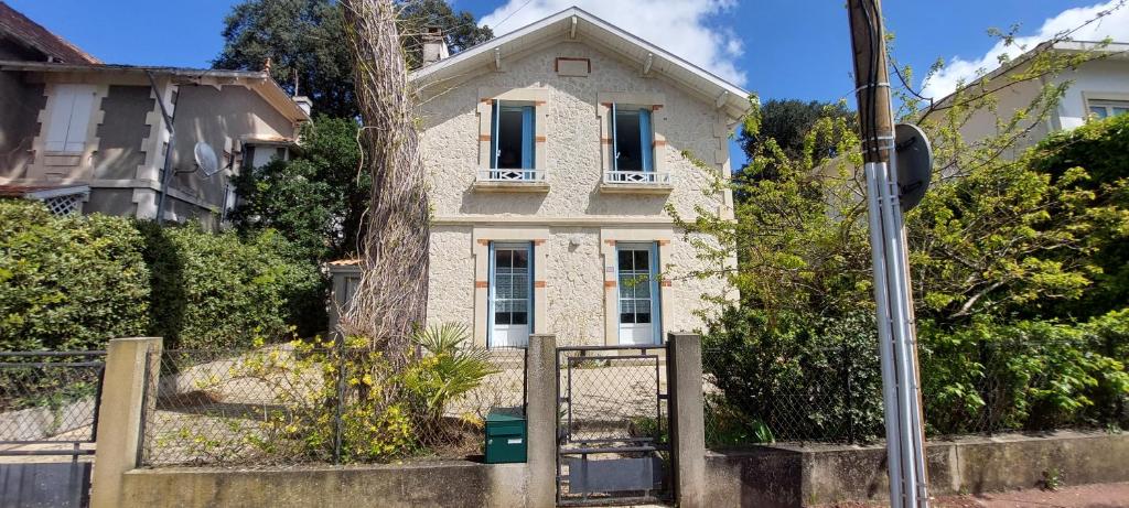 une maison blanche avec une porte en face dans l'établissement VILLA 250 M PLAGE QUARTIER PARC JARDIN GARAGE - Réf 130, à Royan