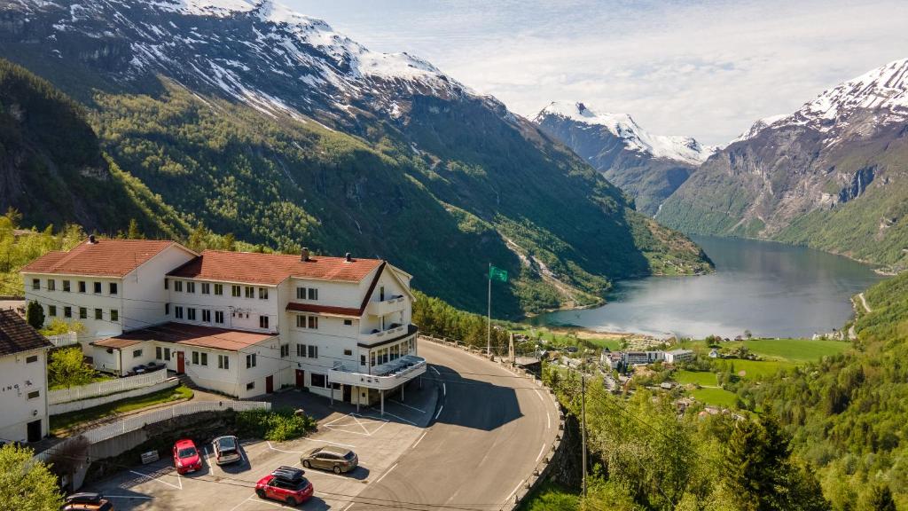 arial view of a building with a lake and mountains at Hotel Utsikten - by Classic Norway Hotels in Geiranger