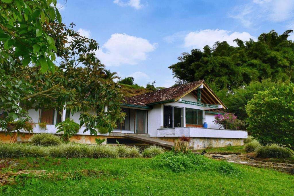 uma pequena casa branca com um jardim de relva em Casa Finca El Carmen Valle del Cauca Colombia 45 min Cali em Papagalleros