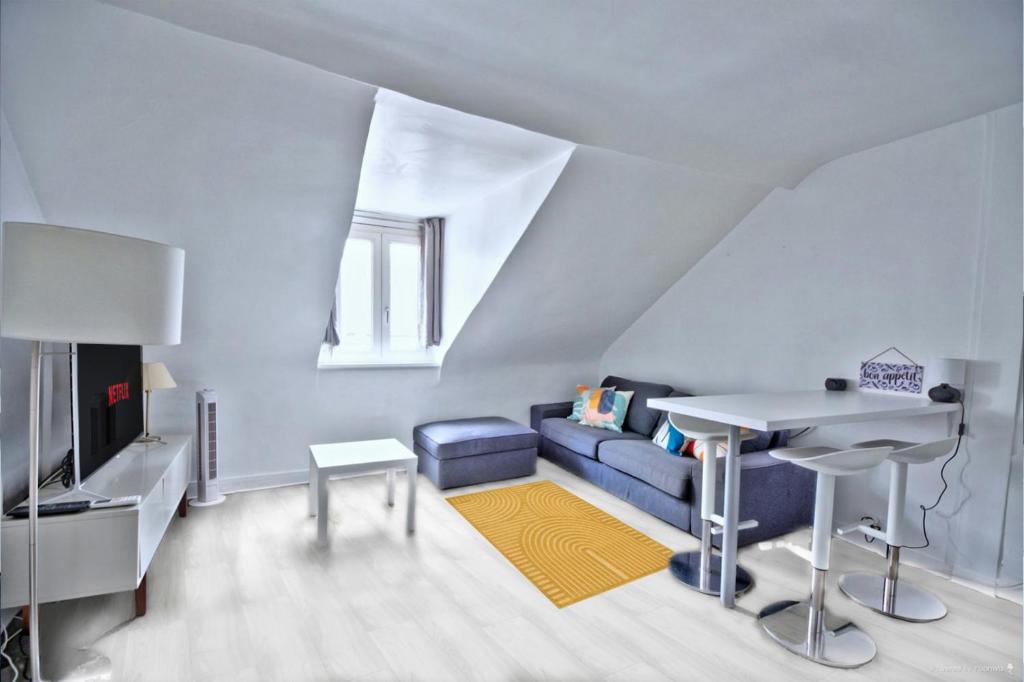 a living room with a blue couch and a table at Promo! near The Pantheon - Latin Quarter! in Paris