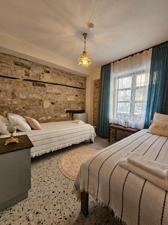 1 Schlafzimmer mit 2 Betten und einer Steinmauer in der Unterkunft Origin Suites Urla in Urla