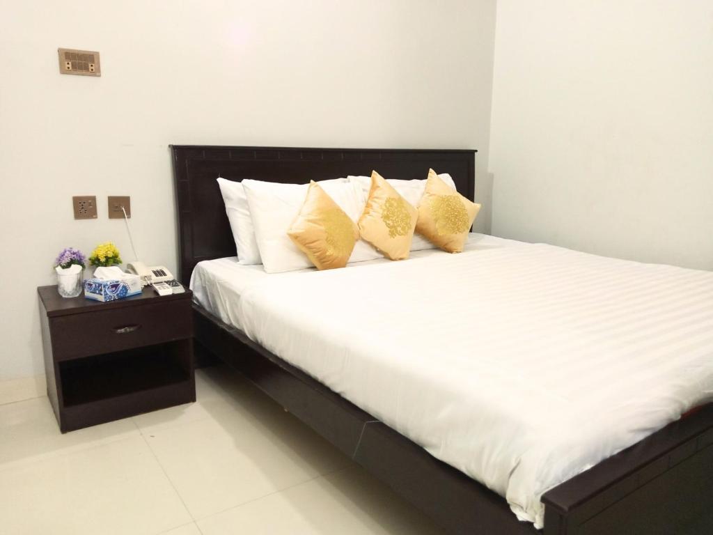 a bedroom with a large bed with yellow pillows at Second Home Guest House Near Agha, Khan Airport in Karachi