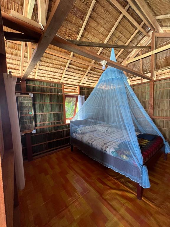 a bed in a room with a mosquito net at Junior Homestay in Kri