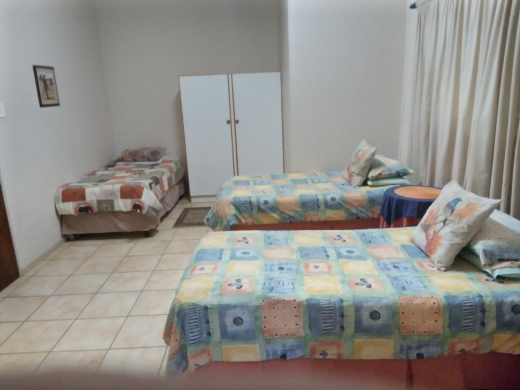 BrandvleiAccommodation Kolarita's Guesthouse, Brandvlei, NC的一间设有两张床的房间和一间设有两张床的房间