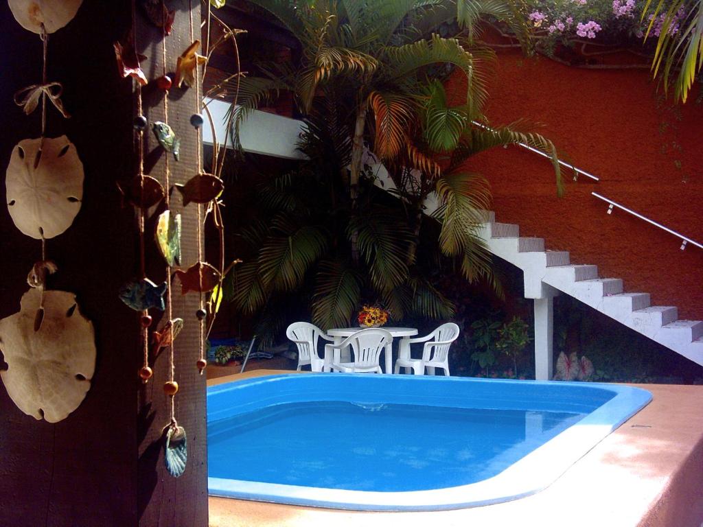 uma piscina com mesa e cadeiras ao lado de um prédio em Pousada do Beijaflor em Florianópolis
