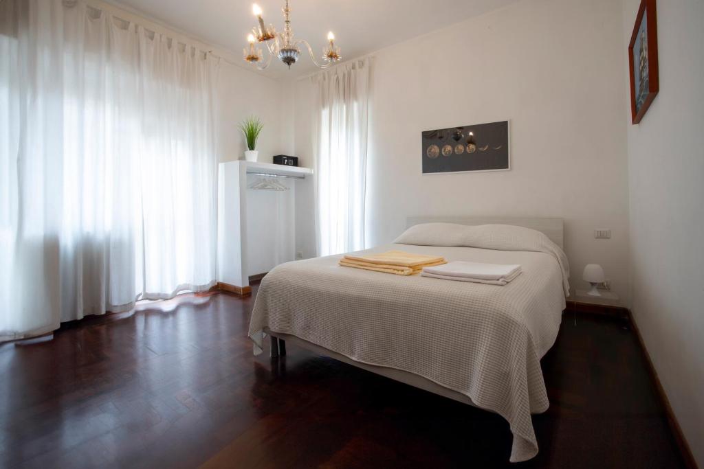 a white bedroom with a bed with two towels on it at 2 Passi Da in Rome