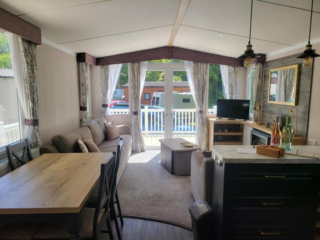 a kitchen and living room with a table and a couch at Remarkable 3-Bed lodge in St Minver in Saint Minver