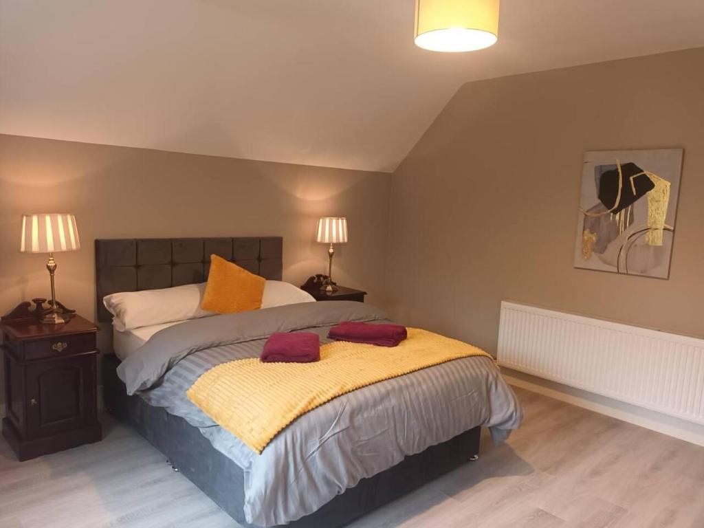 a bedroom with a bed with two red pillows on it at Beautiful House in Killarney county kerry in Coolcorcoran Bridge