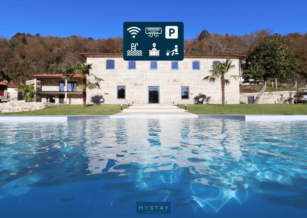a building with a sign above a pool of water at MyStay - Casa d'Henrique in Vieira do Minho