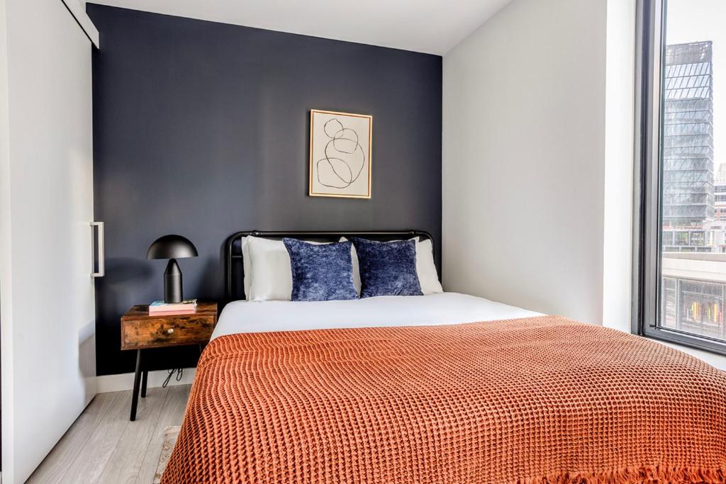 a bedroom with a large bed with blue walls at Seaport studio w fitness close to shops dining BOS-990 in Boston