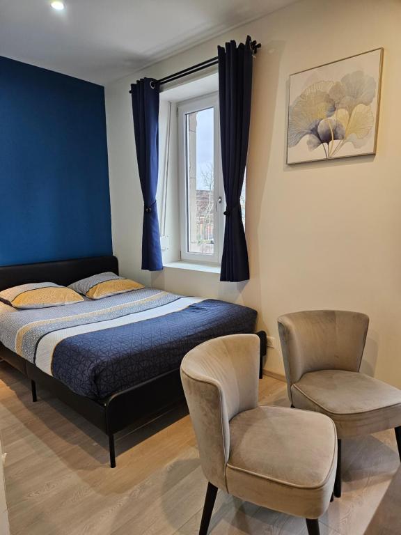 um quarto com uma cama, uma cadeira e uma janela em COLMAR - Appartements Deluxe - Lumineux - Stationnement Gratuit et Facile dans la rue em Colmar