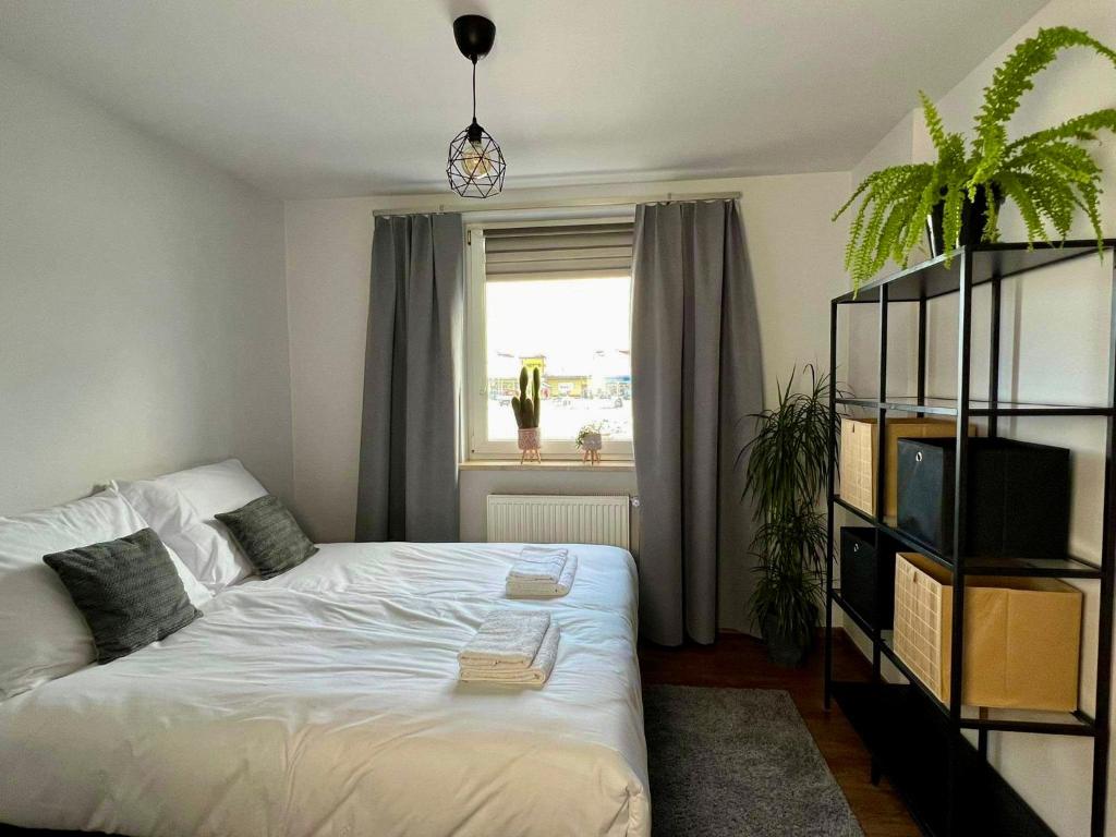 ein Schlafzimmer mit einem weißen Bett und einem Fenster in der Unterkunft Apartament Noce i Dnie z prywatnym jacuzzi in Jaworze