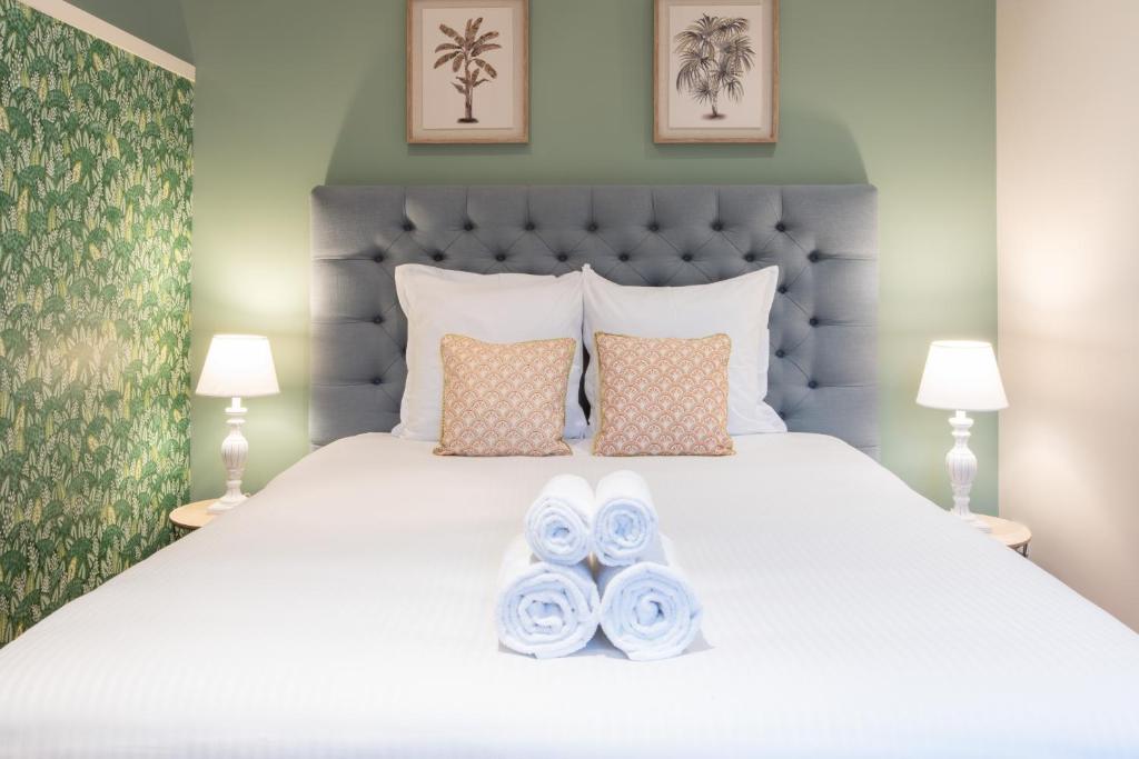een slaapkamer met een groot wit bed en 2 handdoeken bij Escale de Giulia in Beaune