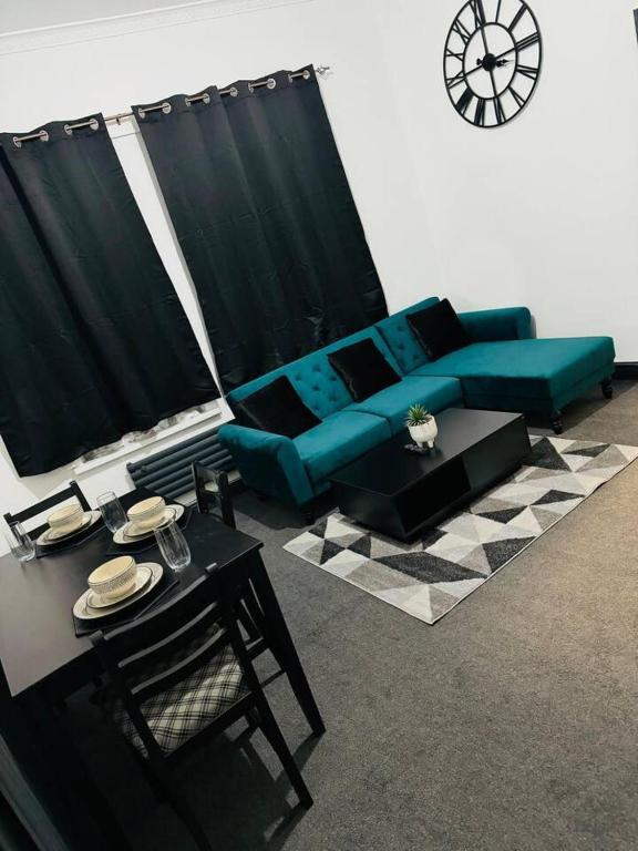 a living room with a blue couch and a table at Elegant 2-Bedroom Apartment near city centre in Birmingham