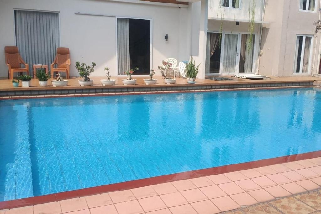 a large blue swimming pool in a building at Aryani Suites Syariah in Jakarta