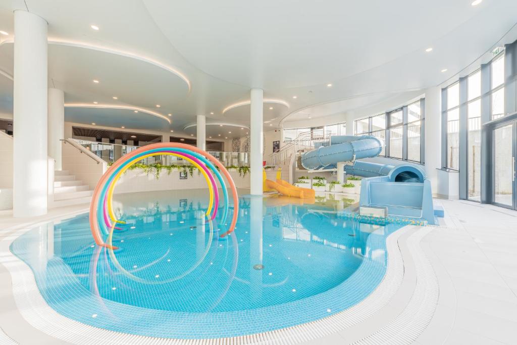 a large swimming pool with a water slide in a building at Jula Aqua Polanki in Kołobrzeg