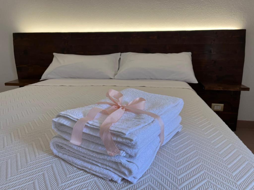 un mucchio di asciugamani con un fiocco rosa su un letto di Casa Sofia a Calascio