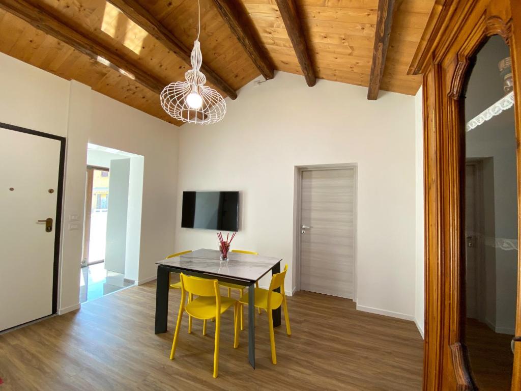 a dining room with a black table and yellow chairs at Levante Flat - 100 m from the beach in Fano