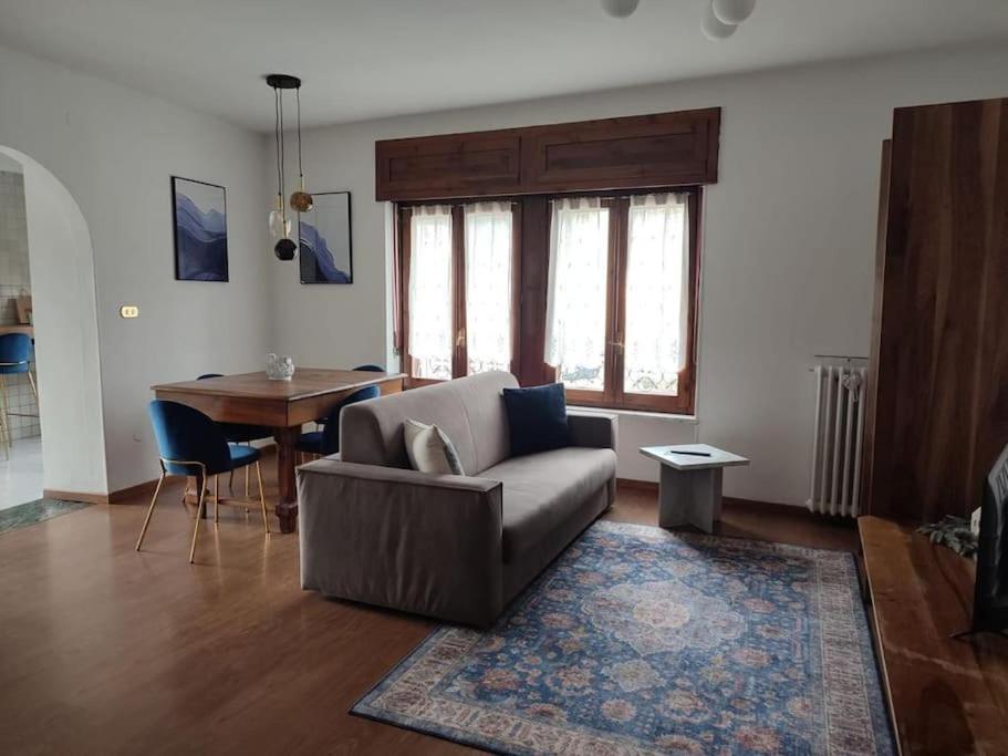 uma sala de estar com um sofá e uma mesa em Neblou em Aosta