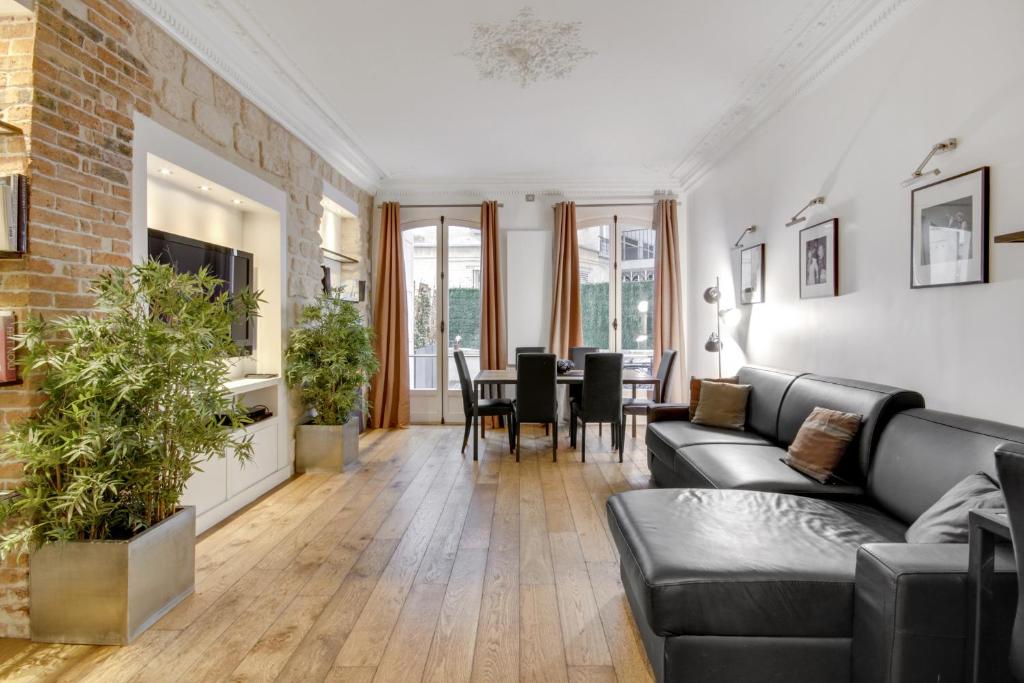 een woonkamer met een bank en een tafel bij Bastille - Gare de Lyon - Appartement familial in Parijs