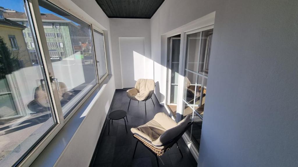 einen Balkon mit 2 Stühlen und einem Fenster in der Unterkunft Apartment- Zimmer Pernter in Köflach