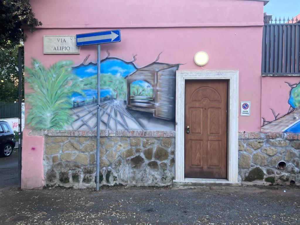 Um edifício cor-de-rosa com uma porta e um quadro. em Pigneto liberty house em Roma