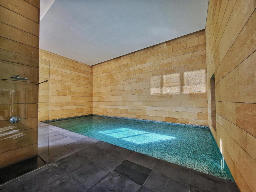 uma piscina num quarto com chuveiro em Monot Suites em Beirute