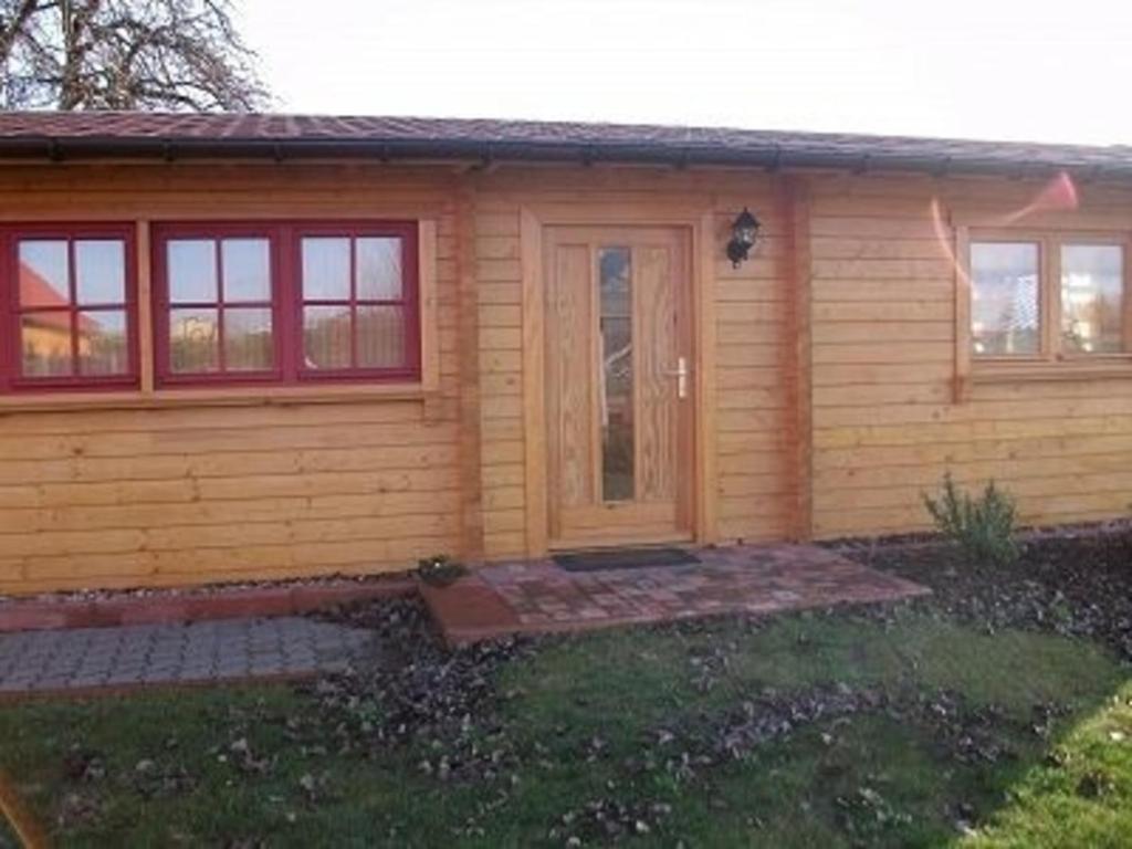 une petite maison en bois avec une porte dans la cour dans l'établissement Ferienhaus Bliev-Hee Nr 5, à Klink
