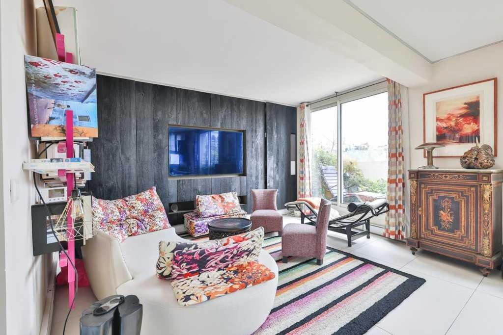 ein Wohnzimmer mit einem weißen Sofa und Stühlen in der Unterkunft Bright functional flat with balcony- view Panthéon in Paris