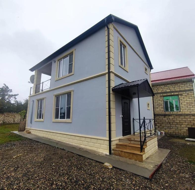 a small white house with a black roof at CiciHome in Qusar