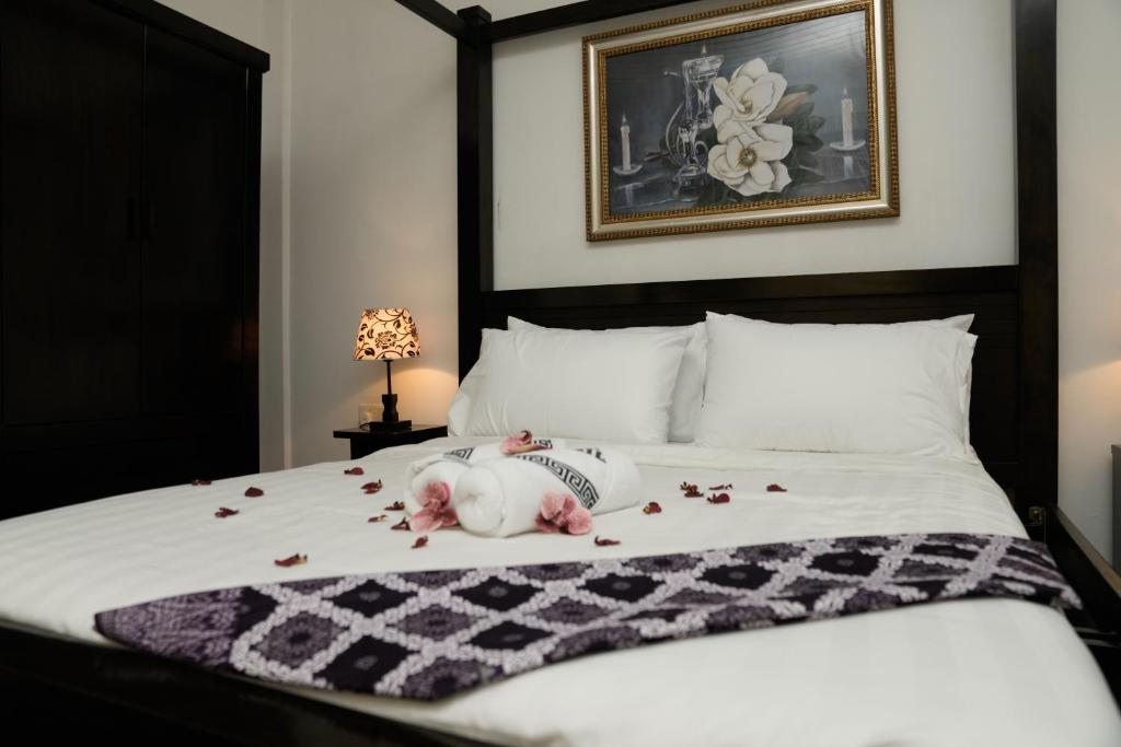 a dog laying on a bed with petals on it at Putera Island Resort in Melaka