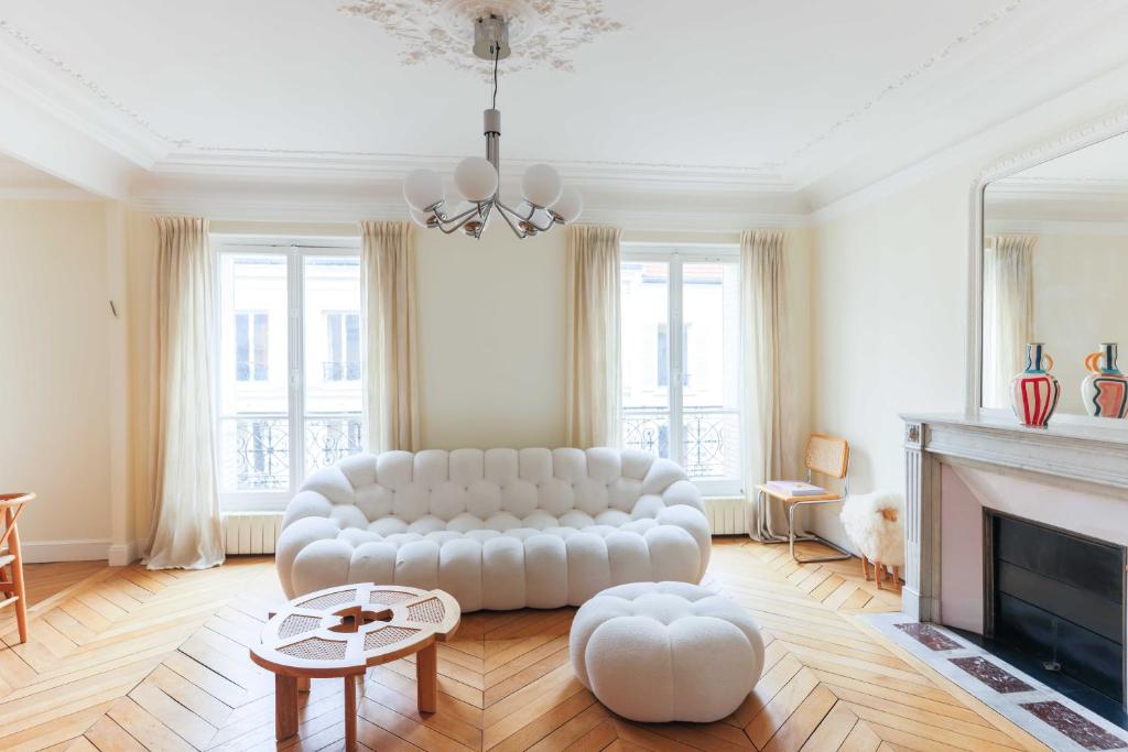 sala de estar con sofá blanco y chimenea en Beautiful 95m2 flat in the heart of Neuilly Sur Seine, en Neuilly-sur-Seine