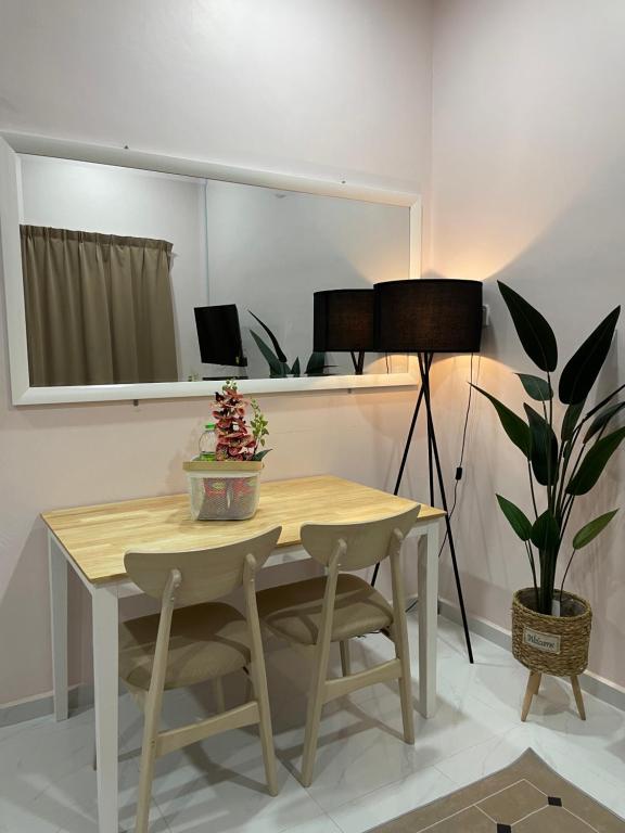 a dining room table with a lamp and a plant at Paktam Ruduwe Homestay in Marang