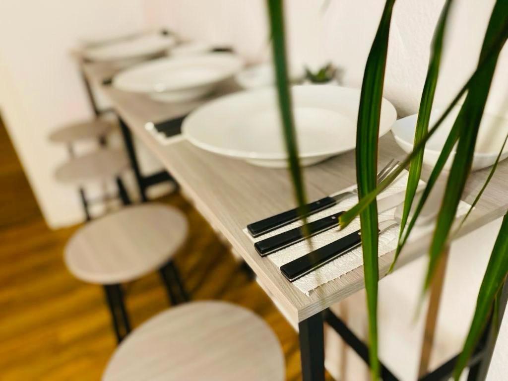 une grande table avec des plaques blanches et une plante dans l'établissement The World, Stilvolles Apartment, Stadtzentral, Parking Free, Late Check In, à Magdebourg