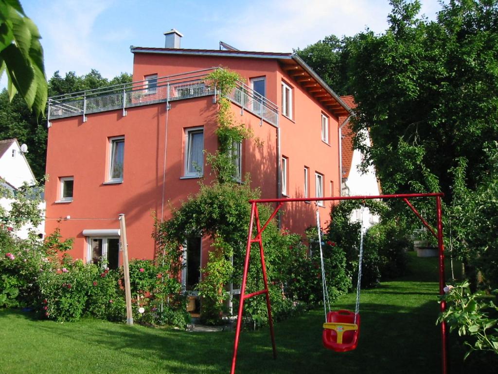 una casa naranja con un columpio en el patio en Ferienwohnung „Rosarium“, en Gunzenhausen
