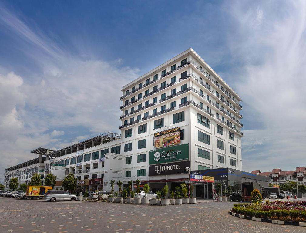 a large white building with a parking lot in front of it at FUHOTEL in Bukit Mertajam