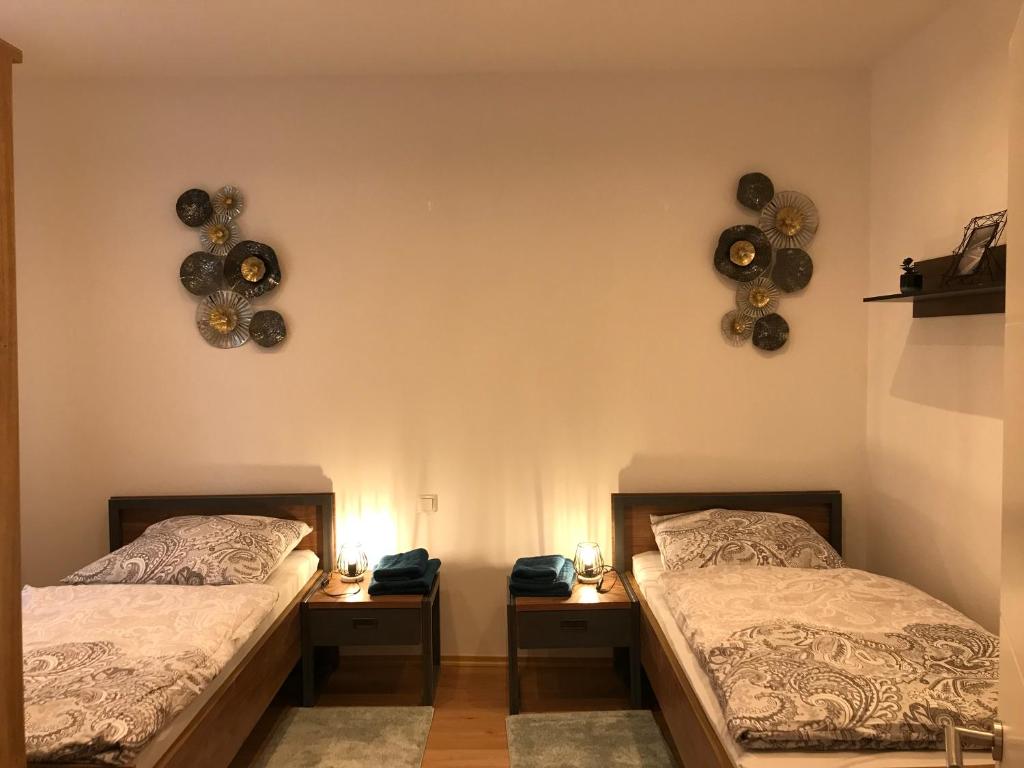 2 lits dans une chambre avec 2 lampes et tambours sur le mur dans l'établissement Mimalou Apartment in Zwickau, à Zwickau