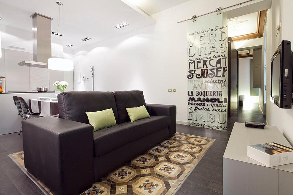 sala de estar con sofá negro y mesa en Ola Living Portaferrissa, en Barcelona