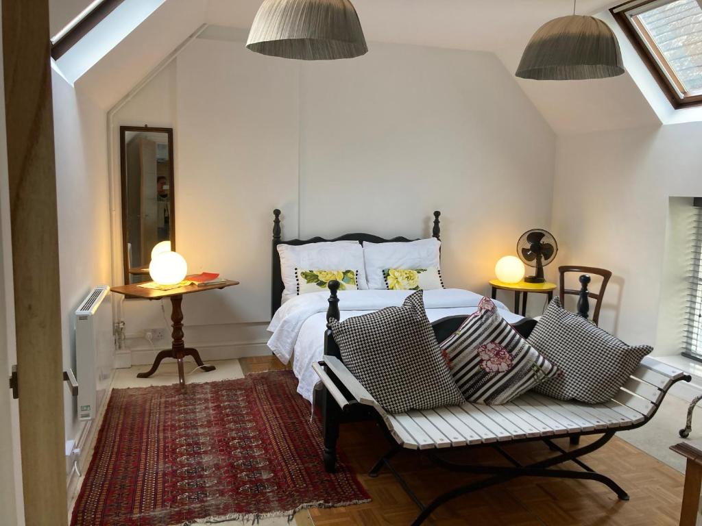 ein Schlafzimmer mit einem Bett mit zwei Stühlen und zwei Lampen in der Unterkunft The loft in Lincolnshire