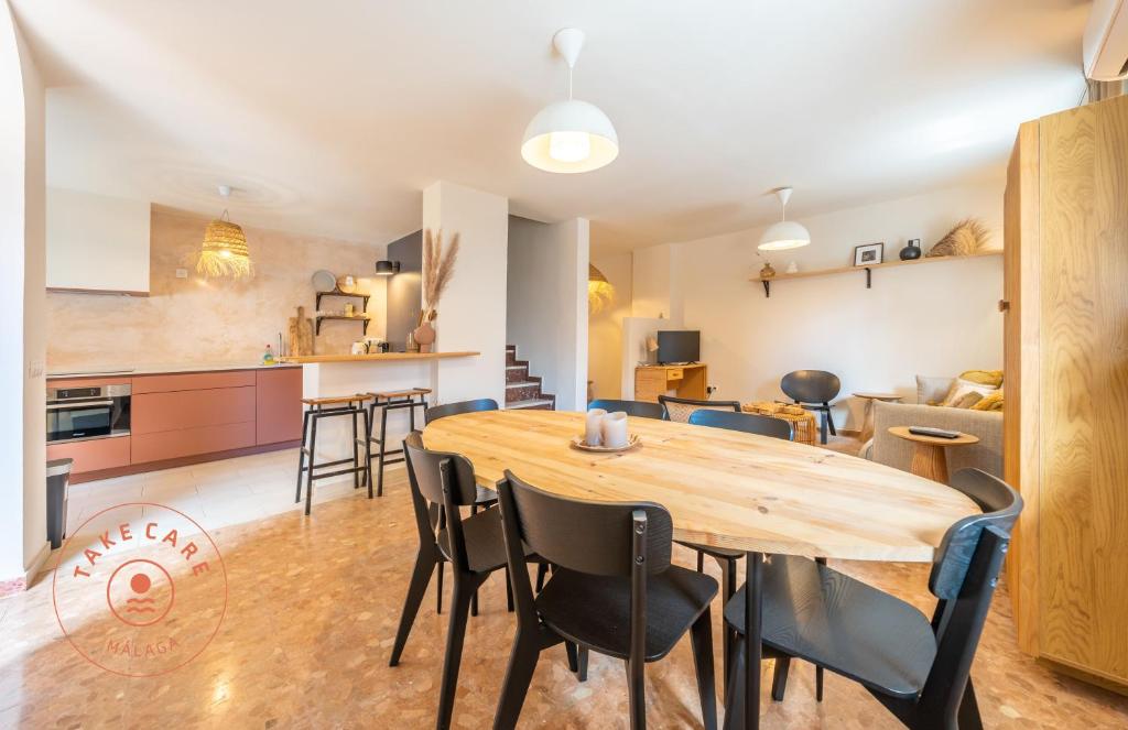 a kitchen and dining room with a wooden table and chairs at House in fishing village El Palo - TCM in Málaga