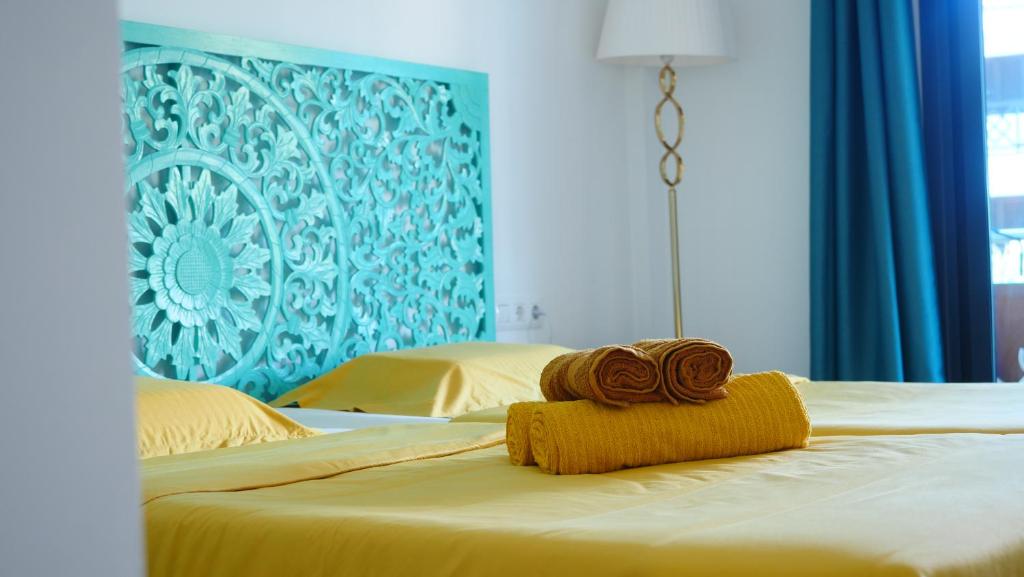 a bed with two rolled towels on top of it at Türkiz Kánaán Apartman in Puerto de Santiago