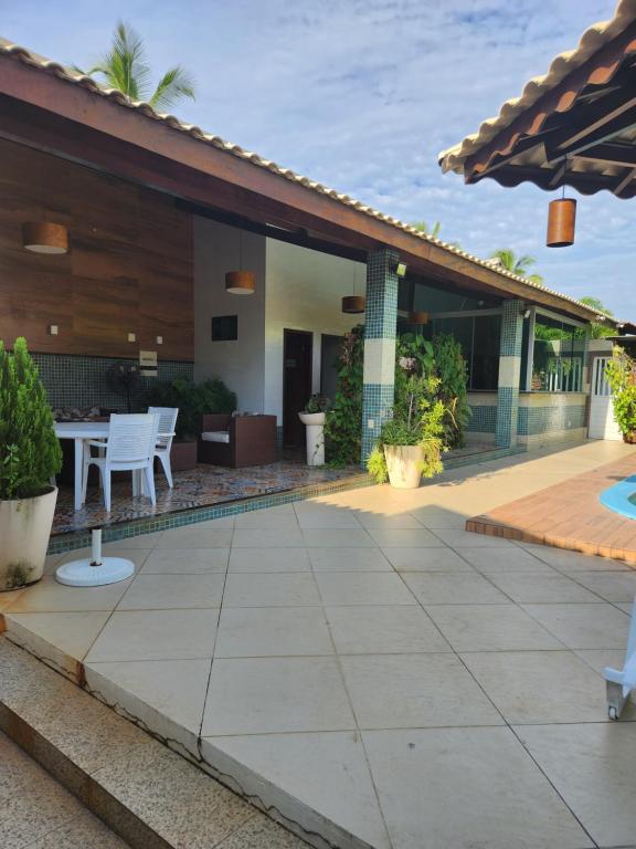 a patio with a table and chairs next to a house at Villa Gardem in Aracaju